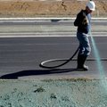 Justin Blisard, owner of Siloam Springs-based Platinum Hydro-Grass, walks between Southwest Regional...