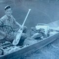J.D. Fletcher shows a black bass he caught from the White River by laying the fish on his paddle. No...