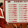 University of Arkansas head football coach Bret Bielema walks past the signing day list of 22 player...
