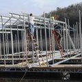 Workers Daniel Harp, from left, Freddie Gomez and Kenny Shanks build a boat dock at Beaver Lake on T...