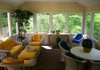 A cheery hue of yellow (No. 25 from the color bars interior designer and author Elaine Ryan created), softened with a layer of white lattice, brightens the sunroom of her home in Connecticut. 