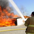 Capt. Dusty Qualls with the Rogers Fire Department stands by Friday during a controlled fire at Arka...
