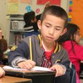 Third-grader Diego Salinas writes vocabulary words Thursday during an exercise with teacher Heather ...