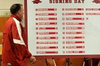 Arkansas head football coach Bret Bielema walks past the signing day list of players who committed to the Razorbacks at a press conference in Fayetteville. 