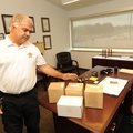 Roger Morris, Washington County coroner, shows one of a few unclaimed cremated human remains that he...