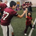 Jesus Pena, 15, left, Springdale football player, high-fives Faelene Traylor, 9, a Special Olympics ...