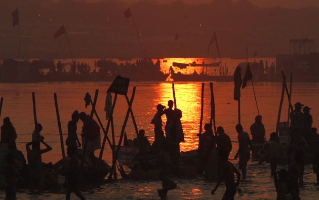 hindu-devotees-pray-against-a-setting-sun-after-a-holy-dip-at-sangam-the-confluence-of-hindu-holy-rivers-ganges-yamuna-and-the-mythical-saraswati-during-the-maha-kumbh-festival-at-allahabad-india-sunday-feb-10-2013-led-by-heads-of-monasteries-arriving-on-chariots-and-ash-smeared-naked-ascetics-millions-of-devout-hindus-plunged-into-the-frigid-waters-of-the-holy-ganges-river-in-india-on-sunday-in-a-ritual-that-they-believe-will-wash-away-their-sins-sunday-was-the-third-of-six-auspicious-bathing-days-during-the-kumbh-mela-or-pitcher-festival-which-lasts-55-days-and-is-one-of-the-worlds-largest-religious-gatherings