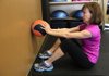 Becky Gilbreath has to contract her core muscles to maintain good lower back posture while doing the Medicine Ball Roller, which uses a weighted ball. 