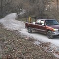 A driver travels on Puppy Creek Road Friday as it turns from a dirt road to a paved road in Springda...