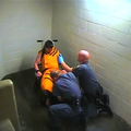 A frame from a video showing Benton County jailers restraining and pepper-spraying an inmate.