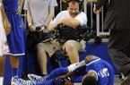 A cameraman grimmaces after a collision with Kentucky forward Nerlens Noel (3) during the second half of an NCAA college basketball game against Florida in Gainesville, Fla., Tuesday, Feb. 12, 2013. Noel injured his left knee and did not return. Florida won 69-52. (AP Photo/Phil Sandlin)