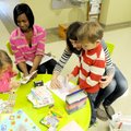 Teachers Bridgett Moore, second from right, and Maerissa Knapp help Liv Erck, 3, left, and Mitchell ...