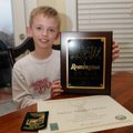 Davis shows his Triple Trophy Award certificate and patch and the plaque Feb. 7 he won for the winni...