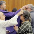 Chuck Marino, left, a deacon, gives ashes to Mary Morrone as the Rev. John Connell give ashes to Ron...