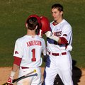 Arkansas first baseman Eric Fisher is greeted by teammate Brian Anderson as he crosses home plate af...