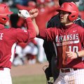 Arkansas' Joe Serrano (10) is congratulated at the plate by Brett McAfee after scoring a run and rec...