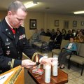 Maj. Mark Golaway, with the Arkansas Army National Guard, lights a candle in honor of Chaplain Georg...