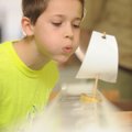 Christopher Guy, 9, of Rogers, a Cub Scout with Pack 5 St. Vincent de Paul in Rogers, blows to move ...