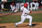 Arkansas batter Tyler Spoon puts the ball into play during his at bat in the sixth inning of the first game in Tuesday afternoon's doubleheader against New Orleans at Baum Stadium in Fayetteville.