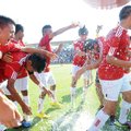D.J. Beeler, Springdale High coach, is doused by his players May 18 after winning the Class 7A state...