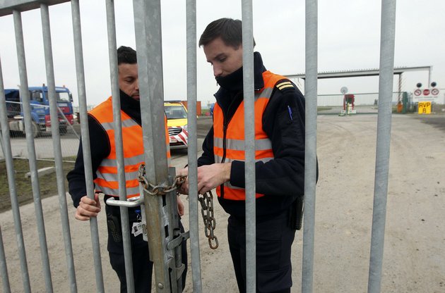 two-airport-police-officers-use-a-chain-to-lock-a-gate-which-leads-to-the-airport-tarmac-at-brussels-international-airport-tuesday-feb-19-2013-eight-masked-gunmen-made-a-hole-in-a-security-fence-at-brussels-international-airport-drove-onto-the-tarmac-and-snatched-some-50-million-worth-of-diamonds-from-the-hold-of-a-swiss-bound-plane-without-firing-a-shot-authorities-said-tuesday