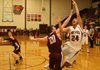 Lincoln junior Ossy Escareno attempts a shot under the basket but is fouled by Gentry sophomore Dustin Stoufflet during tournament play at Gentry High School on February 12th.