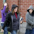 Barbara Long walks with her daughter Jessica, 17, and James, 12, as snow begins to fall while leavin...