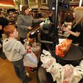 Kira Hungate of West Fork, left, pays for groceries Wednesday while shopping with her son, Colton, 6...