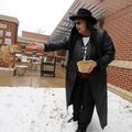 Martha Morrison spreads sand Wednesday on the sidewalk around the Bentonville Public Library as the ...