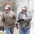 Rick Garrison, left, and Dan Kondik walk in a heavy snowfall Wednesday along Northwest A Street in B...