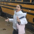 Ashley Munoz, 10, catches snowflakes on her tongue Wednesday as she walks from a school bus to the A...
