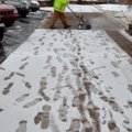 Craig Caperton with Fayetteville works Wednesday clearing the snow from the sidewalk around the city...