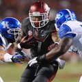 Arkansas running back Knile Davis carries the ball as Kentucky defensive lineman Mike Douglas, right...