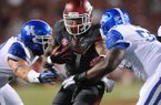 Arkansas running back Knile Davis carries the ball as Kentucky defensive lineman Mike Douglas, right, closes in to make the tackle during the second quarter of play Saturday, Oct. 13, 2012, at Razorback Stadium in Fayetteville.