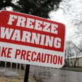 A sign warning residents of overnight freezing temperatures is coated with a layer of ice Thursday a...