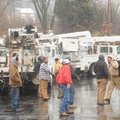 Utility crews from Texas and Kansas gather Thursday around their trucks outside the Days Inn in Faye...