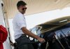Franz von Holzhausen, chief designer at Tesla Motors Inc., demonstrates the charging system on a Tesla S sedan in Lebec, Calif. The carmaker said it plans to deliver 20,000 of its battery-powered cars this year. 