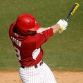 Arkansas' Tyler Spoon follows through on an at-bat against Evansville on Saturday, Feb. 23, 2013, at...