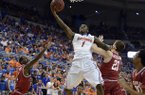 Florida guard Kenny Boynton (1) goes to the basket as Arkansas guard Mardracus Wade (1) and forward Hunter Mickelson (21) defend during the first half of an NCAA college basketball game in Gainesville, Fla., Saturday, Feb. 23, 2013. (AP Photo/Phil Sandlin)