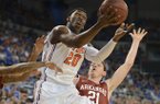 Florida's Erik Murphy (33) tries to block Arkansas guard Michael Qualls (24) as he struggles under the basket during the first half of an NCAA college basketball game in Gainesville, Fla., Saturday, Feb. 23, 2013. (AP Photo/Phil Sandlin)