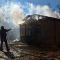 Mitchelle Jones helps put water on the hot spots after a fire broke out at his home at 426 E. Bob La...