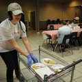 Jessica Sanders reaches for a plate of food Tuesday while serving visitors at the Samaritan Center C...