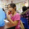 Daisy Melendez eats an apple Thursday as part of her breakfast in Kelli Wineman’s second-grade class...