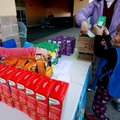 Addison Carr, left, 6, and Ella Osmola, 5, both with Daisy Troop 5360 in Rogers, arrange boxes of Gi...
