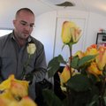 Jonathan Edwards, co-owner of Pigmint Floral & Event Design, processes roses Friday inside his trail...