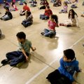 Second-graders in Josh Hicklin’s physical education class stretch Monday morning in the gym at Elmda...