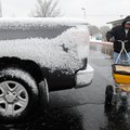 Robert Musi of Rogers spreads rock salt Tuesday at First National Bank of Rogers during snowfall.
L...