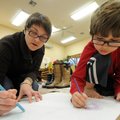 Loki Lowe, 5, right, and his mother, Carrie Wilks, work Tuesday on coloring a map of North America d...