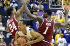 LSU's Charles Carmouche (00) is sandwiched between Arkansas' Michael Qualls (24) and Mardracus Wade (1) during their NCAA college basketball game, Wednesday, Feb. 27, 2013, in Baton Rouge, La. LSU won 65-60. (AP Photo/The Advocate, Heather McClelland)