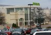 Shoppers come and go Friday at Park Plaza mall, where an after-hours robbery and shooting on Thursday left one food-court restaurant employee dead and another in critical condition. Police arrested two suspects within hours of the shooting. 